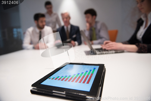 Image of close up of touchpad with analytics documents at business meetin