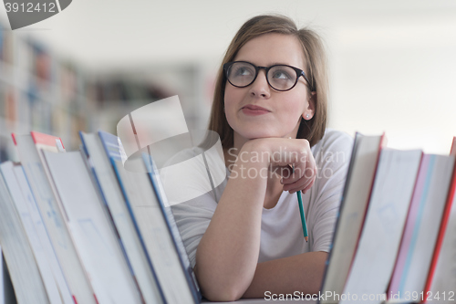 Image of portrait of famale student selecting book to read in library