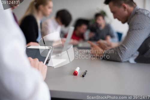 Image of close up of  businessman hands  using tablet on meeting