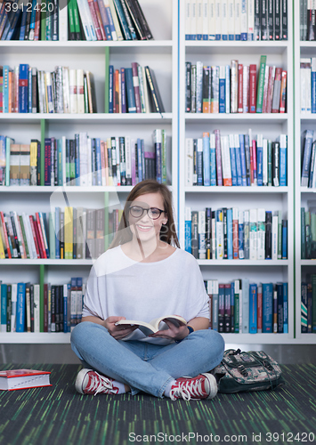 Image of famale student reading book in library