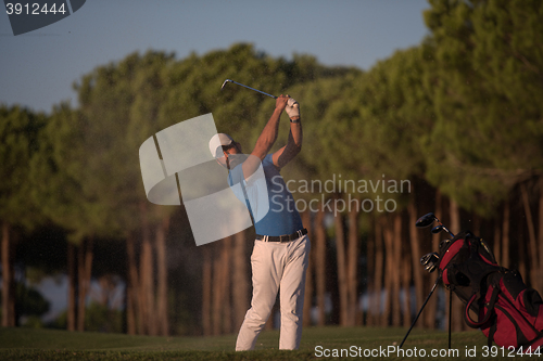 Image of golfer hitting a sand bunker shot on sunset