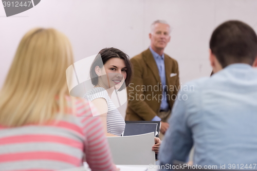 Image of teacher with a group of hi school students in classroom