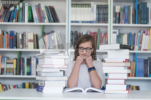 Image of female student study in library, using tablet and searching for 