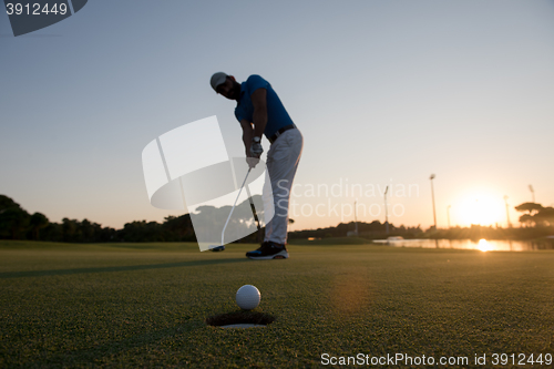 Image of golfer  hitting shot at golf course