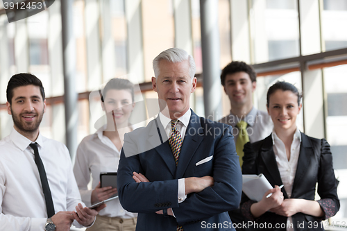 Image of portrait of senior businessman as leader  with group of people i