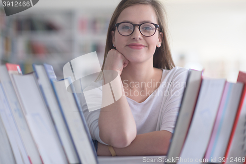 Image of portrait of famale student selecting book to read in library