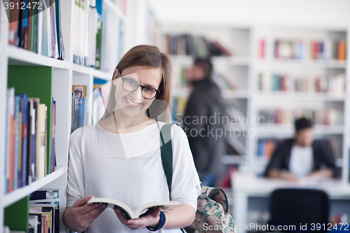 Image of portrait of famale student reading book in library