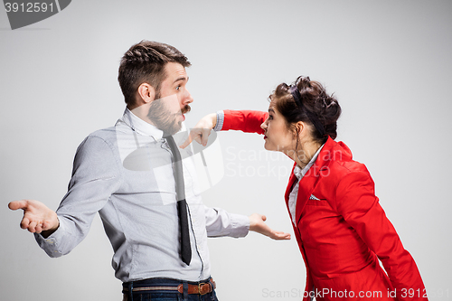 Image of The angry business man and woman conflicting on a gray background