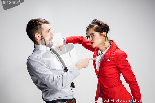 Image of The angry business man and woman conflicting on a gray background