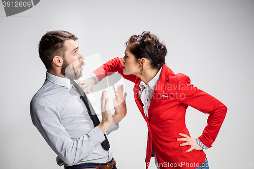 Image of The angry business man and woman conflicting on a gray background