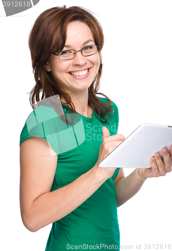 Image of Young cheerful woman is using tablet