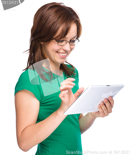 Image of Young cheerful woman is using tablet