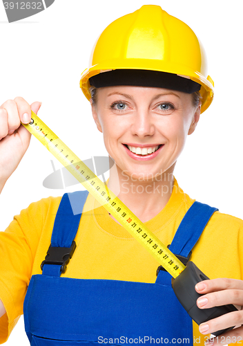 Image of Young construction worker with tape measure