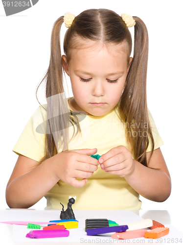 Image of Little girl is playing with plasticine