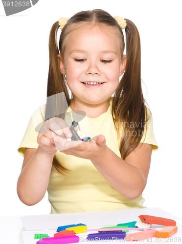 Image of Little girl is playing with plasticine