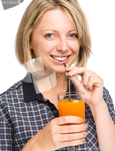 Image of Young woman is drinking carrot juice