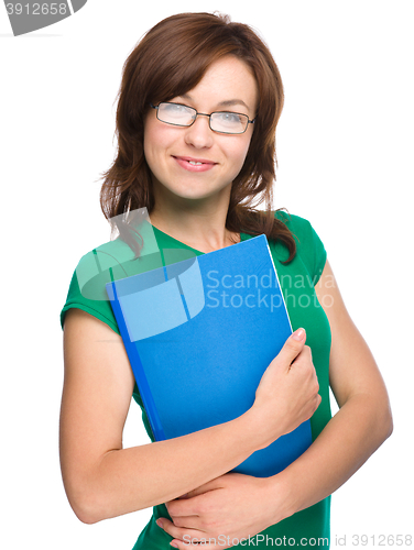 Image of Young skinny student girl is holding exercise book