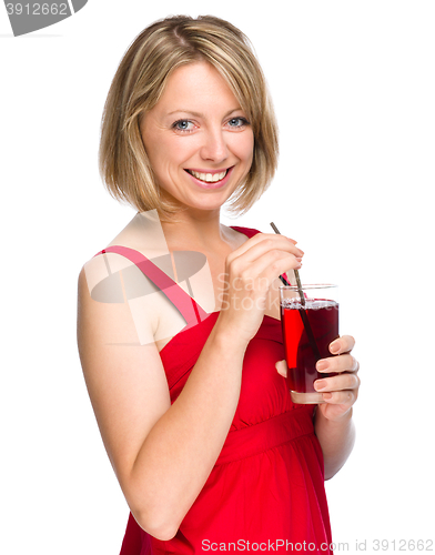 Image of Young woman is drinking cherry juice