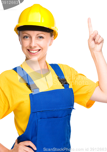 Image of Young construction worker pointing up
