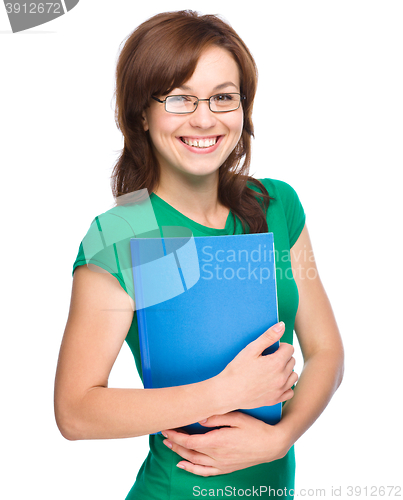 Image of Young skinny student girl is holding exercise book