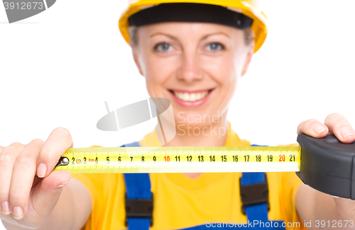 Image of Young construction worker with tape measure