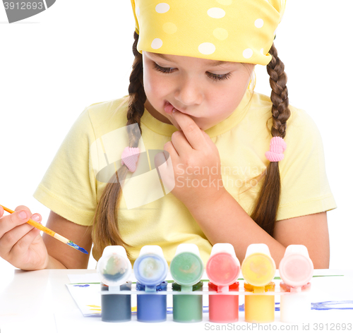 Image of Cute thoughtful child play with paints