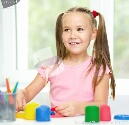 Image of Girl is having fun while playing with plasticine