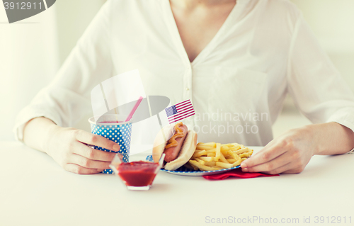 Image of close up of woman eating hotdog and french fries