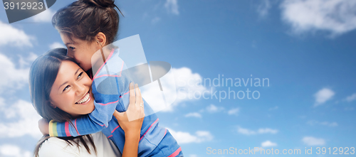 Image of hugging mother and daughter over sky background