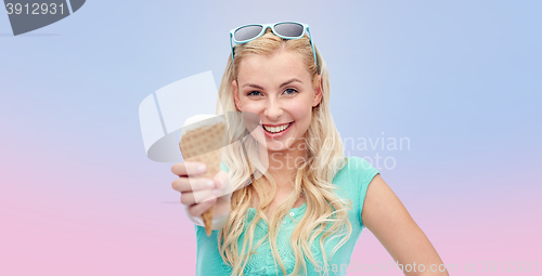 Image of happy young woman in sunglasses eating ice cream