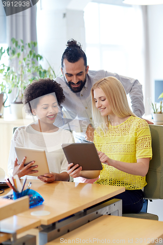 Image of happy creative team with tablet pc in office