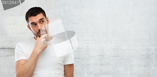 Image of man thinking over gray wall background
