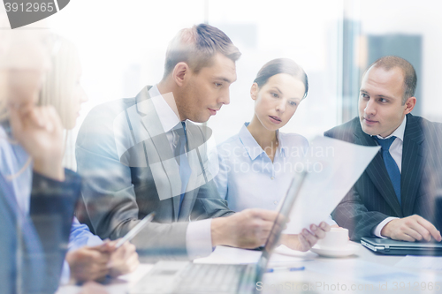 Image of business team with laptop having discussion