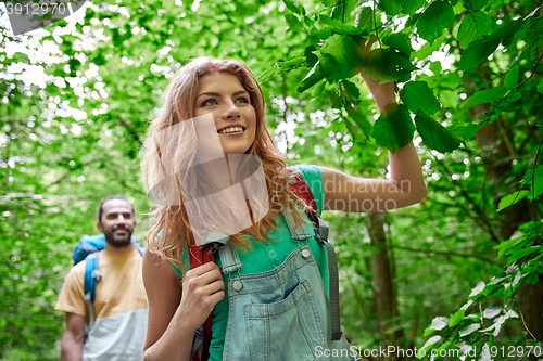 Image of happy couple with backpacks hiking in woods