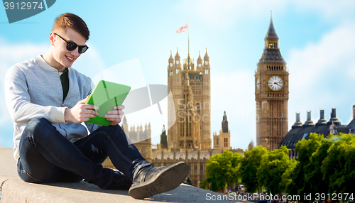 Image of happy young man with tablet pc over london city