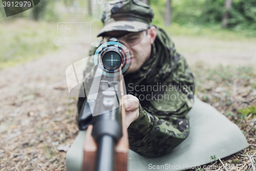 Image of close up of soldier or sniper with gun in forest