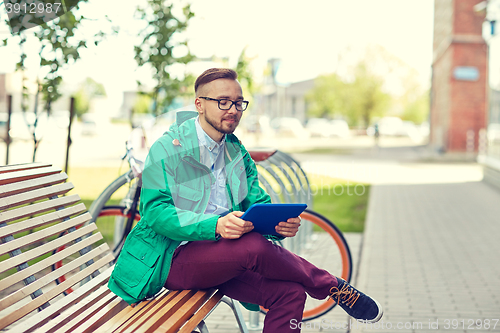 Image of happy young hipster man with tablet pc and bike