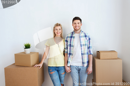 Image of smiling couple with big boxes moving to new home