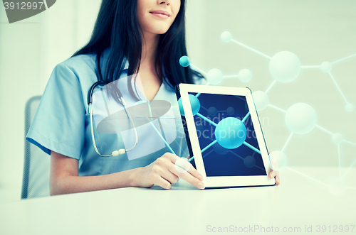 Image of close up of doctor showing molecules on tablet pc