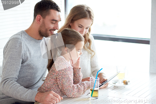 Image of happy family with tablet pc at restaurant