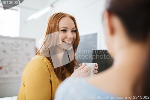 Image of happy creative team drinking coffee at office