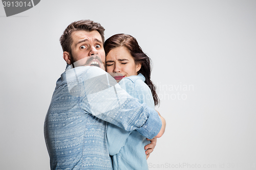 Image of Emotional facial expression wide eyed couple, woman an man looking surprised open mouth