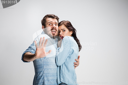 Image of Emotional facial expression wide eyed couple, woman an man looking surprised open mouth