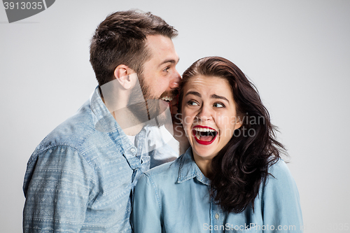 Image of Young man whispering to woman a secret