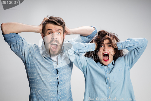 Image of Close up photo of angry man and woman touching their heads