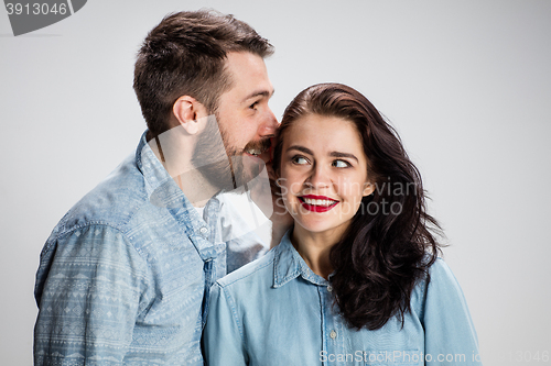 Image of Young man whispering to woman a secret
