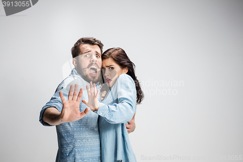 Image of Close up Shocked Young Couple with Mouth and Eyes Wide Open Looking at Camera on gray Background.