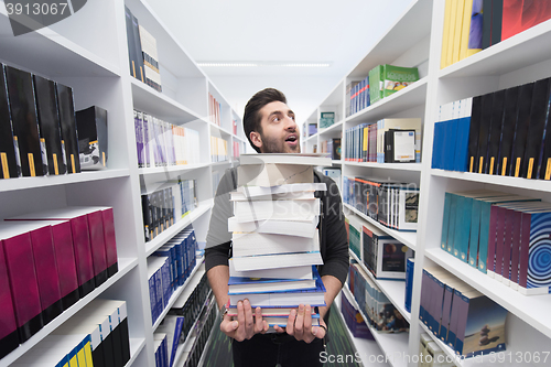 Image of Student holding lot of books in school library