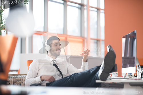 Image of relaxed young business man at office