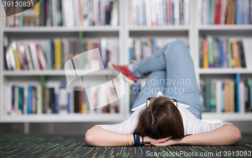 Image of female student study in library, using tablet and searching for 